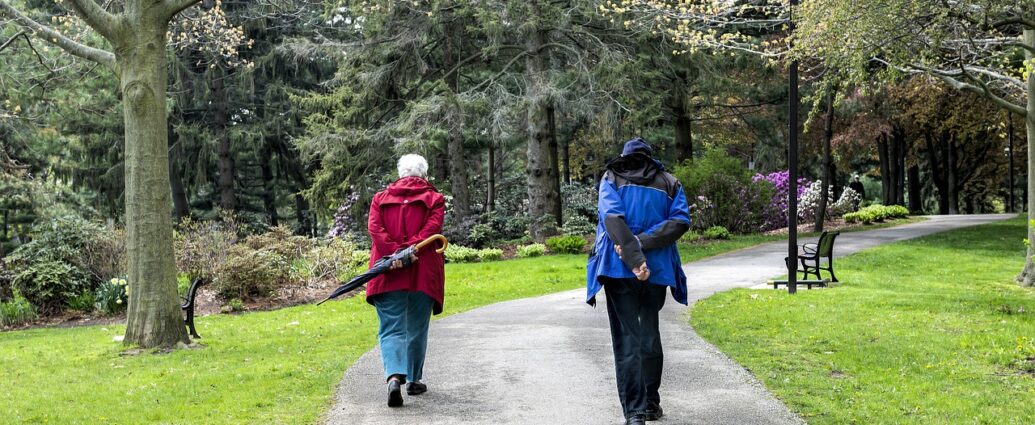 Kuracjusze seniorzy na spacerze w parku zdrojowym