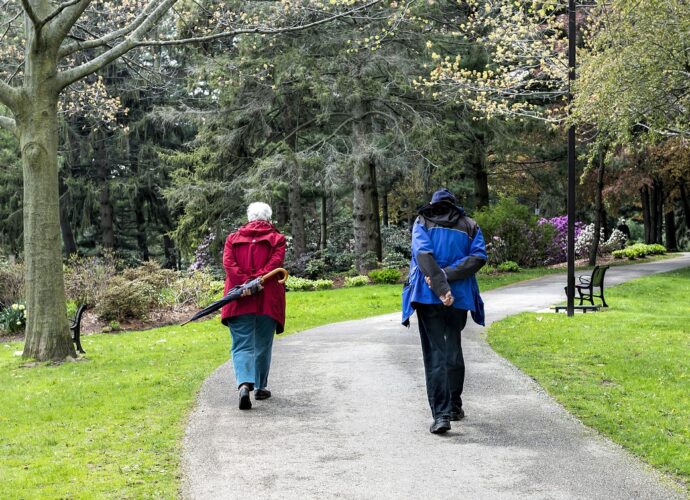 Kuracjusze seniorzy na spacerze w parku zdrojowym