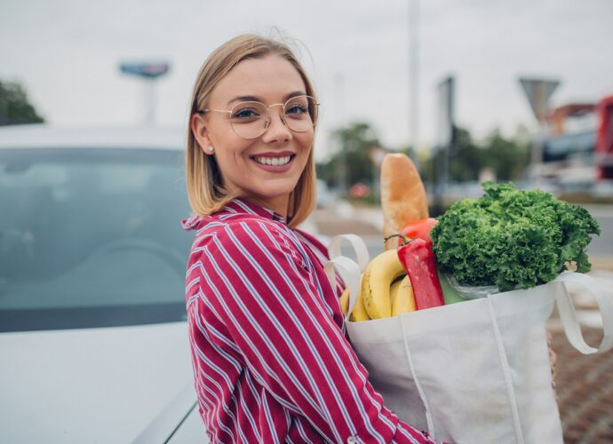 Dziewczyna trzyma papierowa torbę z produktami wegańskimi