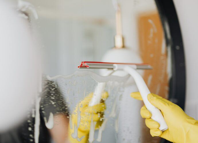 Profesjonalne czyszczenie lustra za pomocą ściągaczki do szyb