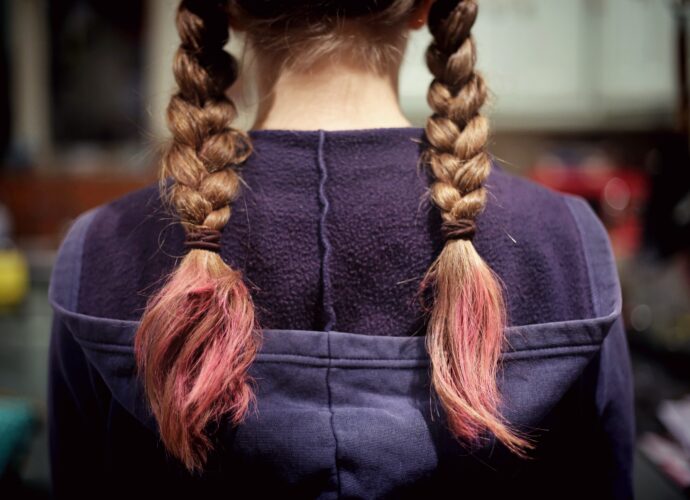 Dziewczyna ze zniszczonymi włosami zaplecionymi w warkocze. Fot. Emma Simpson