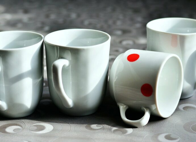 Białe kubki porcelanowe na kamiennym blacie