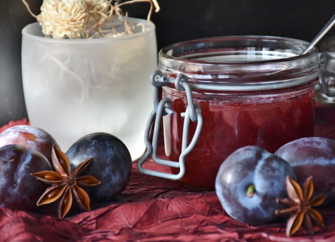 Słoik z powidłami śliwkowymi i świeże śliwki węgierki
