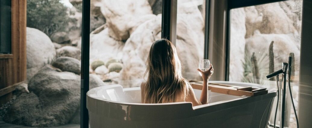Relaks w kąpieli - kobieta odpoczywa wwannie z kieliszkiem wina