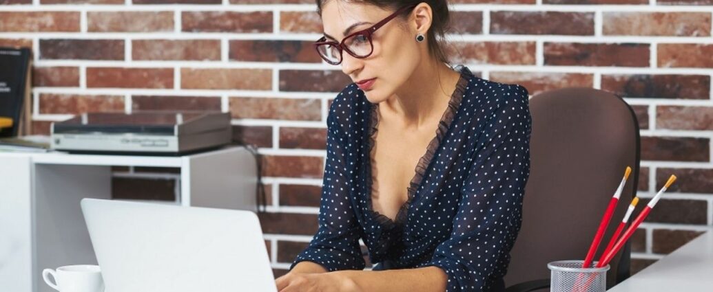 Kobieta w okularach pracuje przy laptopie