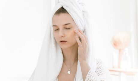 Kobieta pielęgnuje skórę twarzy i włosy emolientami