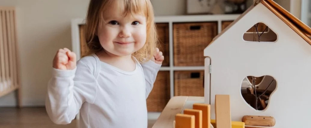 Dziewczynka w czasie zabawy w drewnianym domku