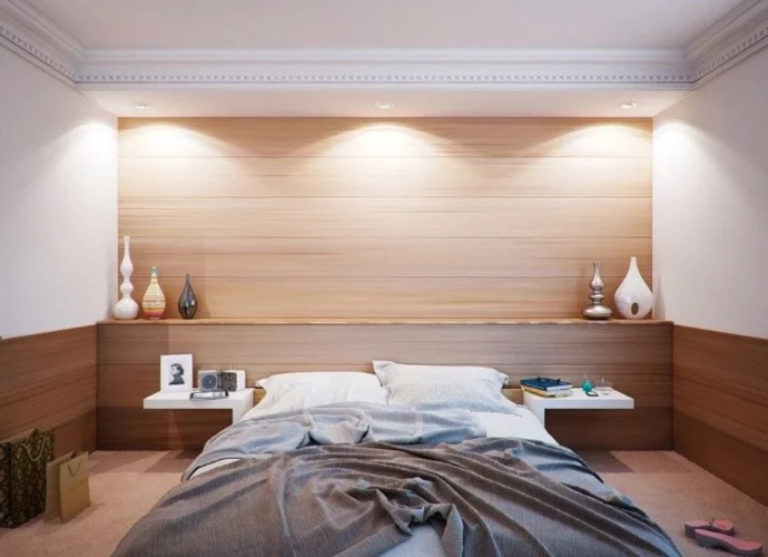 Elegancka sypialnia z oświetleniem nad wezgłowiem łóżka