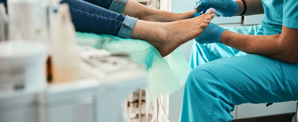 Podolog wykonuje zabieg na stopach