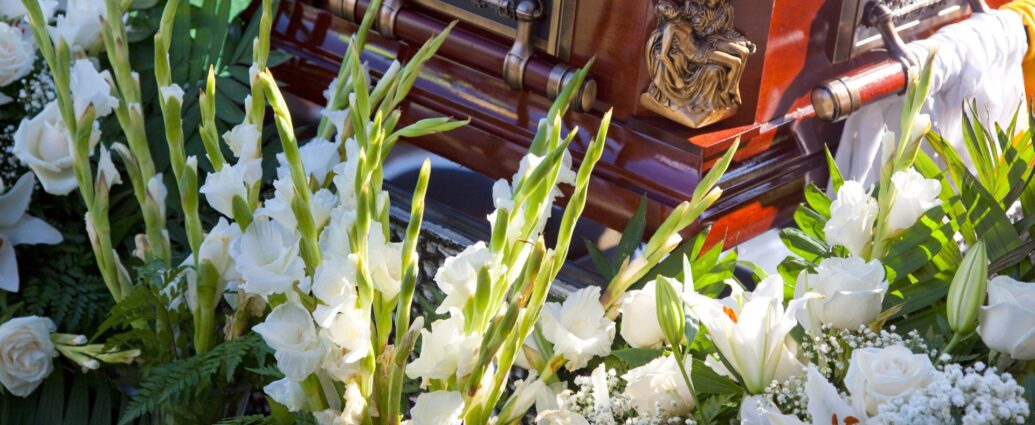 Białe kwiaty wokół trumny
