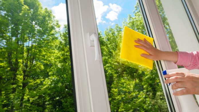Mycie szyb w oknach latem w czasie słonecznej pogody