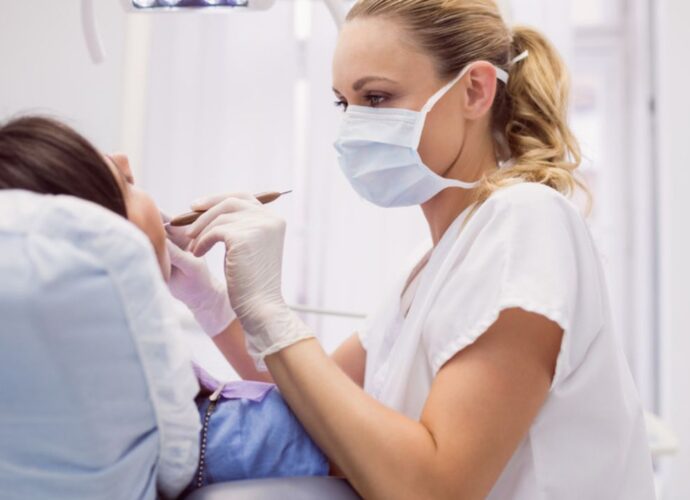 Dentystka leczy zęby pacjentowi w gabinecie