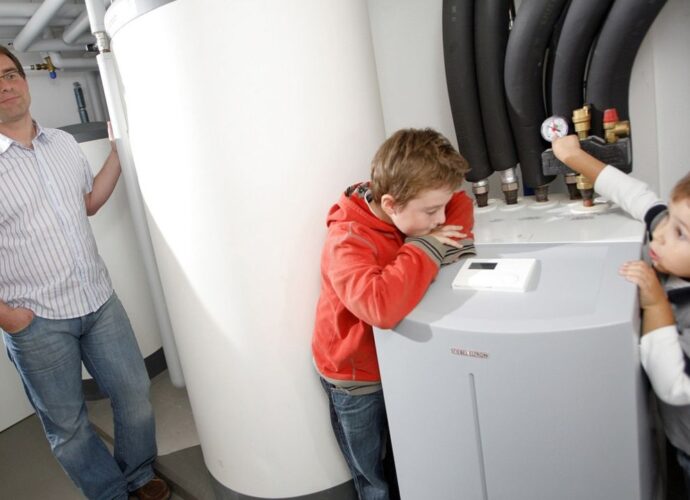 Instalacja obsługująca pompę ciepła - przy niej tata z synami