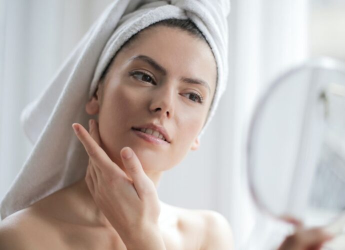 Kobieta stosuje kosmetyki do pielęgnacji twarzy