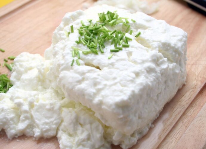 Twaróg, czyli biały ser na desce, posypany szczypiorkiem
