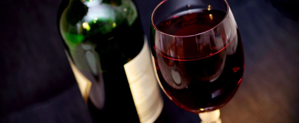 Butelka czerwonego wina i kieliszek