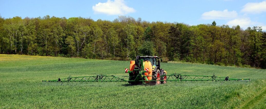 Maszyna rolnicza opryskująca uprawy na polu