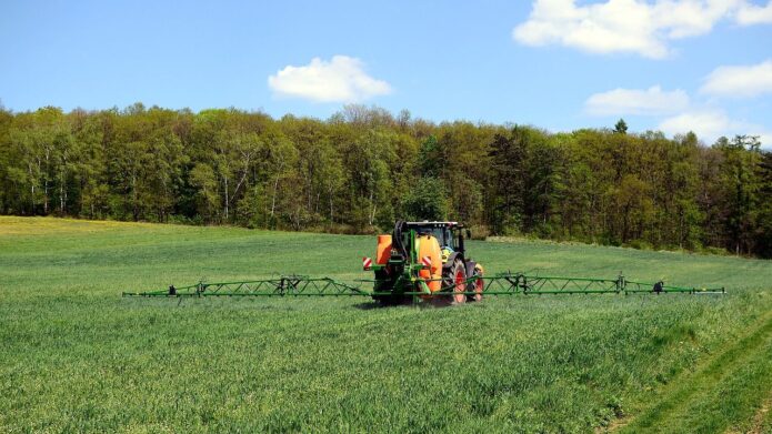 Maszyna rolnicza opryskująca uprawy na polu