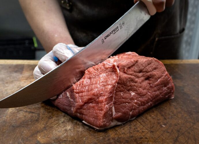 Krojenie świeżego mięsa nożem masarskim