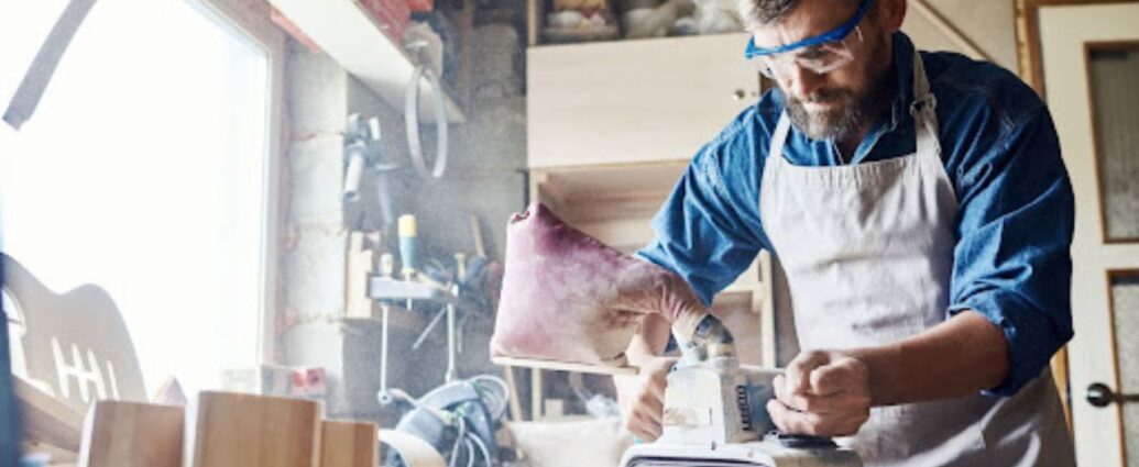 Praca szlifierką taśmową w warsztacie