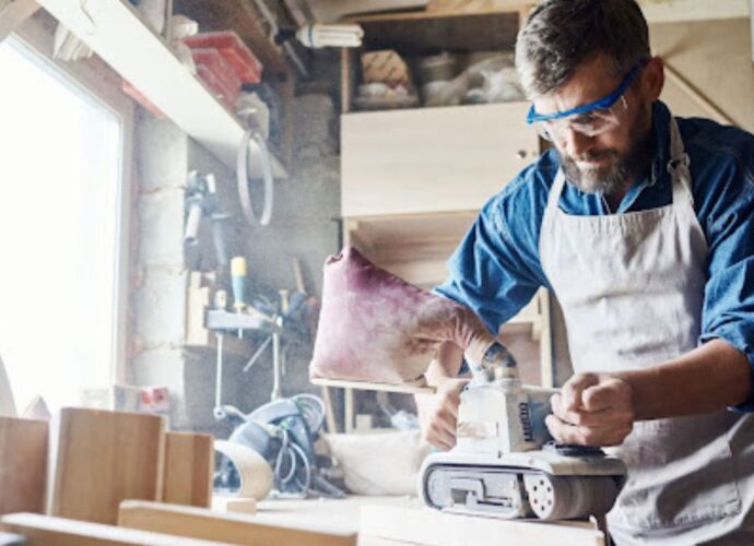 Praca szlifierką taśmową w warsztacie