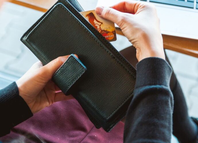 Kobieta trzyma w dłoniach czarny portfel