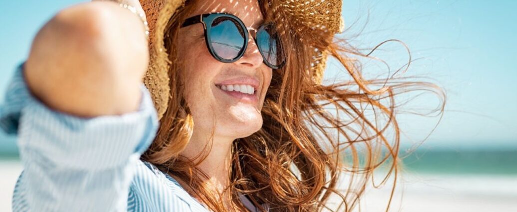 Kobieta w okularach przeciwsłonecznych i plażowym kapeluszu