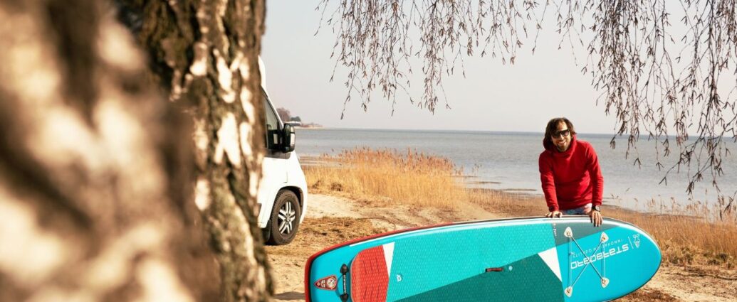 Mężczyzna z deską sup na plaży