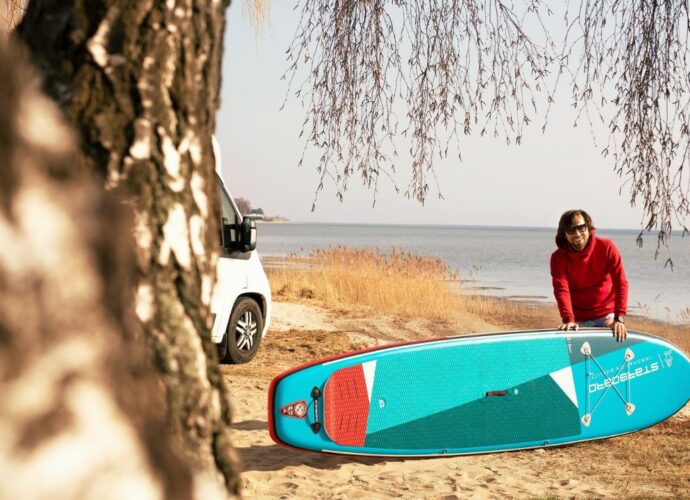 Mężczyzna z deską sup na plaży