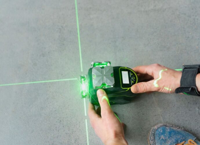 Pracownik wykonuje pomiary miernikiem laserowym