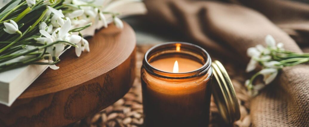 Ekskluzywna świeca zapachowa, obok ziaren kawy i przebiśniegów