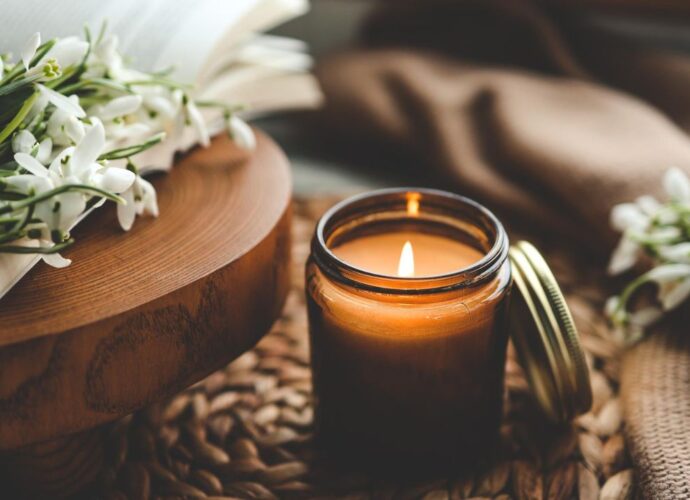 Ekskluzywna świeca zapachowa, obok ziaren kawy i przebiśniegów