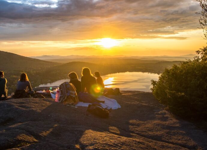 Grupa pracowników w czasie wyjazdu słuzbowego w góry podziwia zachód słońca