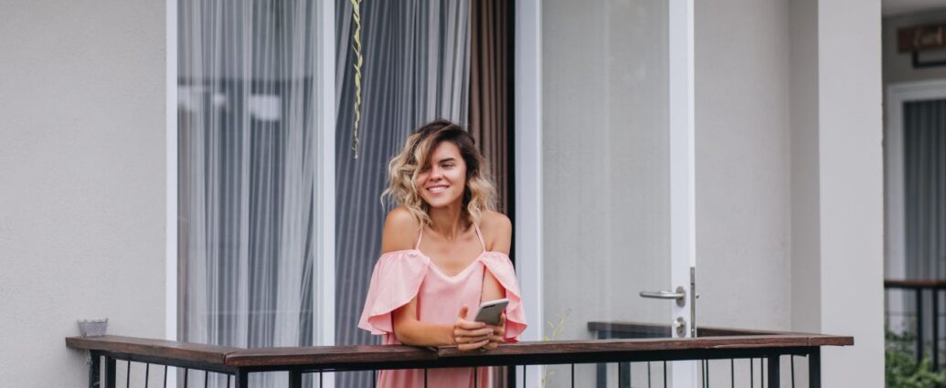 Młoda kobieta stoi na balkonie