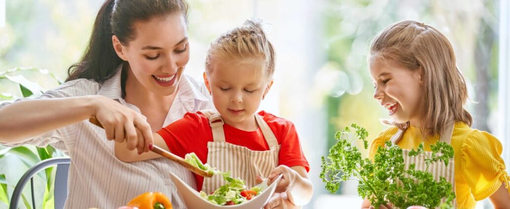Mamy przygotowuje zdrowy posiłek z córkami