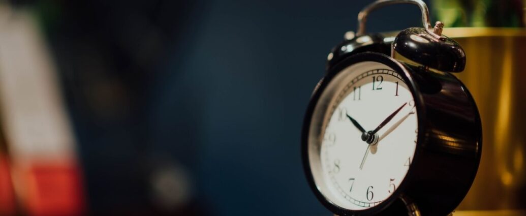 Zegar w formie budzika stojący na komodzie