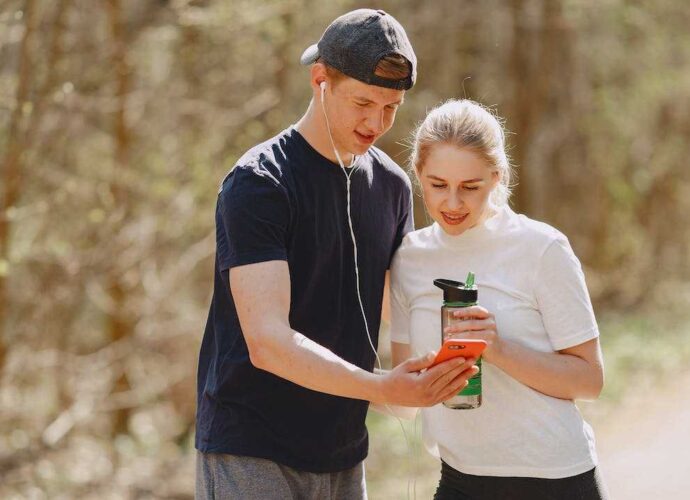 Młodzi ludzie w czasie treningu mierzą kroki za pomocą smartwatcha