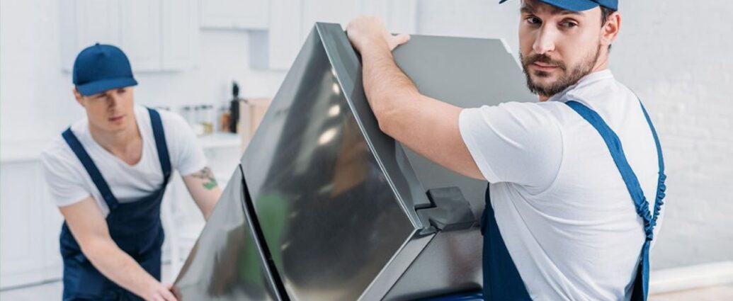 Pracownicy wynoszą stary sprzęt elektroniczny, czyli elektrośmieci