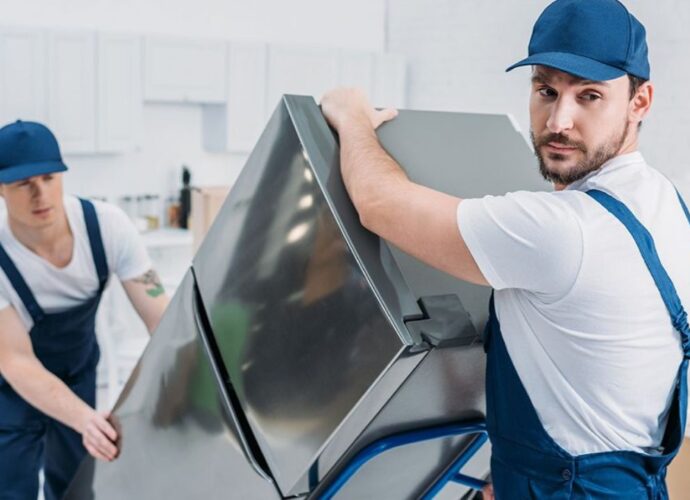 Pracownicy wynoszą stary sprzęt elektroniczny, czyli elektrośmieci