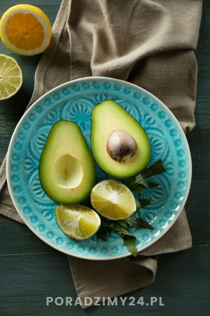 Połówki awokado i ćwiartki cytryny na niebieskim talerzu