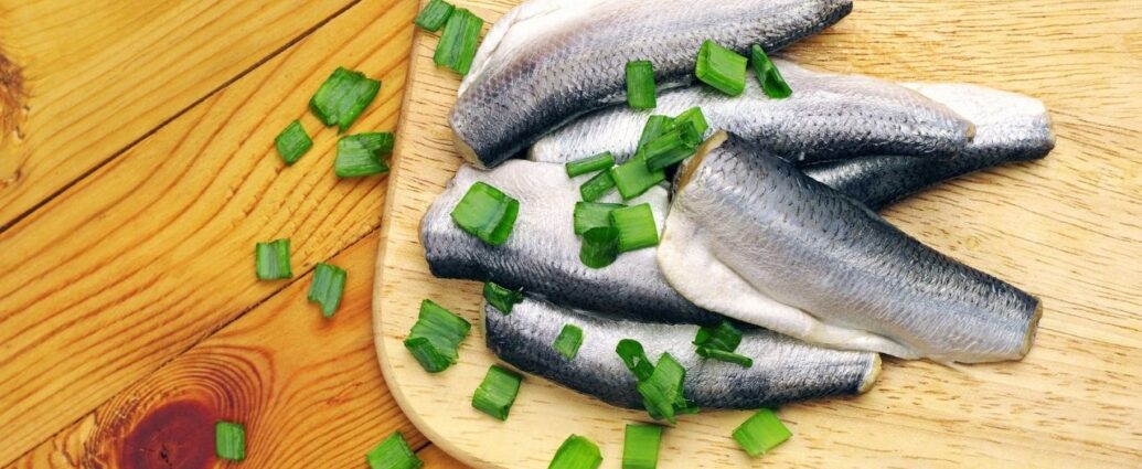 Śledzie na drewnianej desce do krojenia