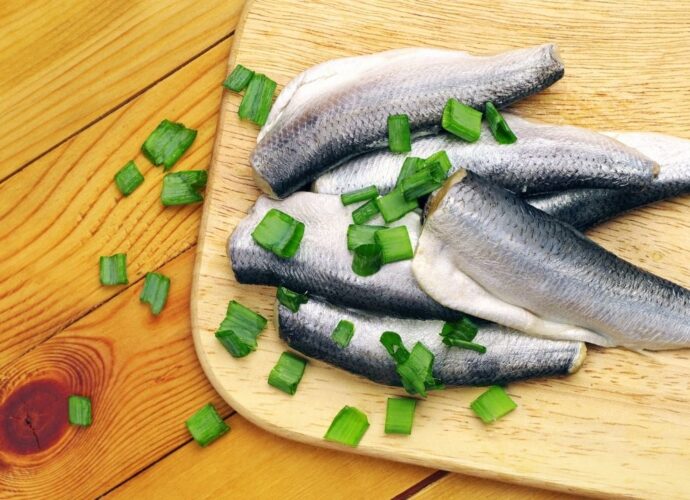 Śledzie na drewnianej desce do krojenia