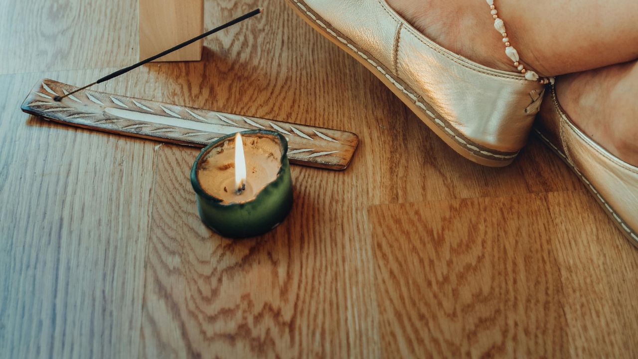 Świeczka ustawiona na drewnianej podłodze