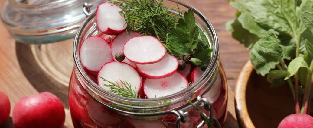 Jak kisić rzodkiewkę? Pokrojone rzodkiewki w słoiku przygotowane do kiszenia