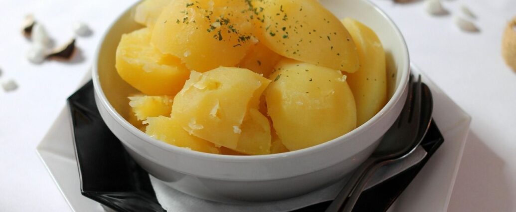 Gotowane ziemniaki w białej misce, posypane ziołami
