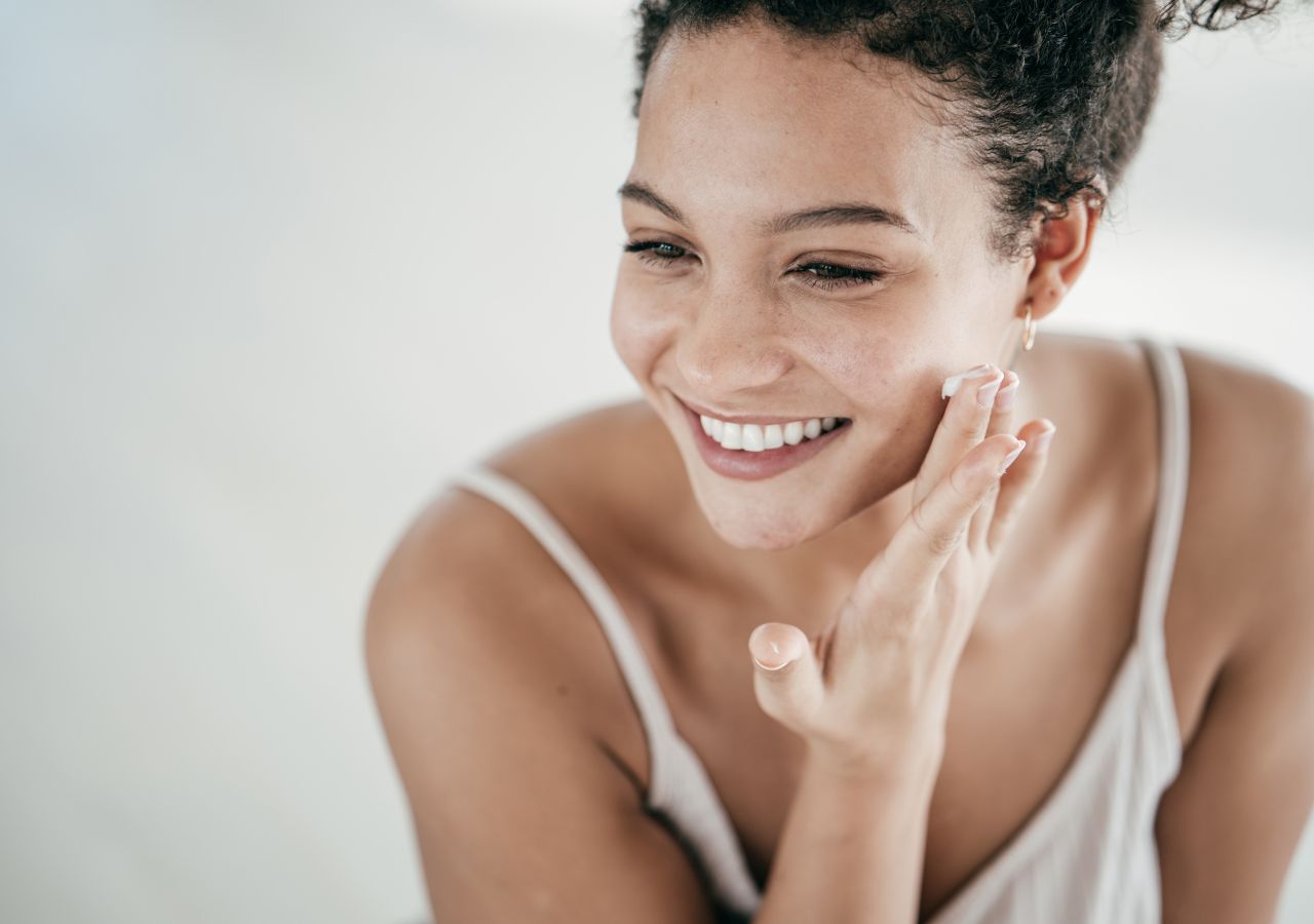 Młoda kobieta stosuje kosmetyki z dodatkiem retinolu