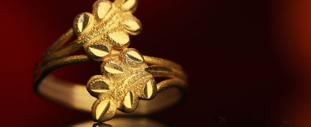 Złoty pierścionek z motywem liści na ciemnym tle