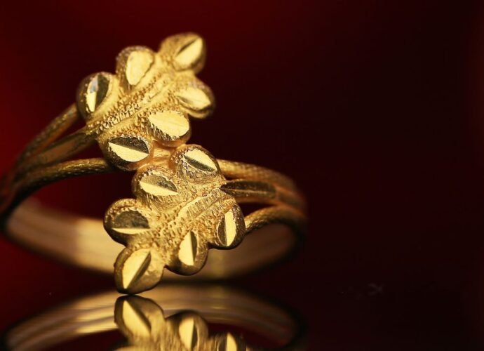 Złoty pierścionek z motywem liści na ciemnym tle