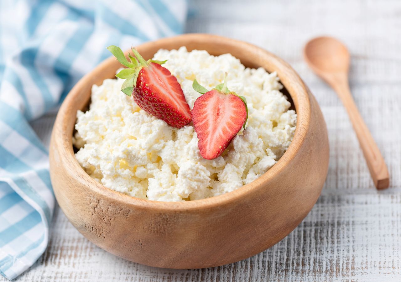 Kvarg ze świeżymi truskawkami, podany w drewnianej misce