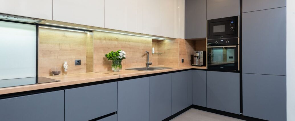 Kuchnia urządzona meblami zaprojektowanymi na wymiar w kolorze stalowo-niebieskim